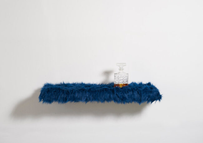 Furry wallshelf Fluffy with whiskey bottle front view